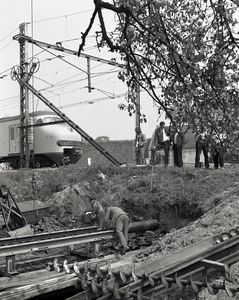 802341 Afbeelding van het boren van gasbuizen door het talud in de spoorlijn Utrecht-Amsterdam bij de spoorwegovergang ...